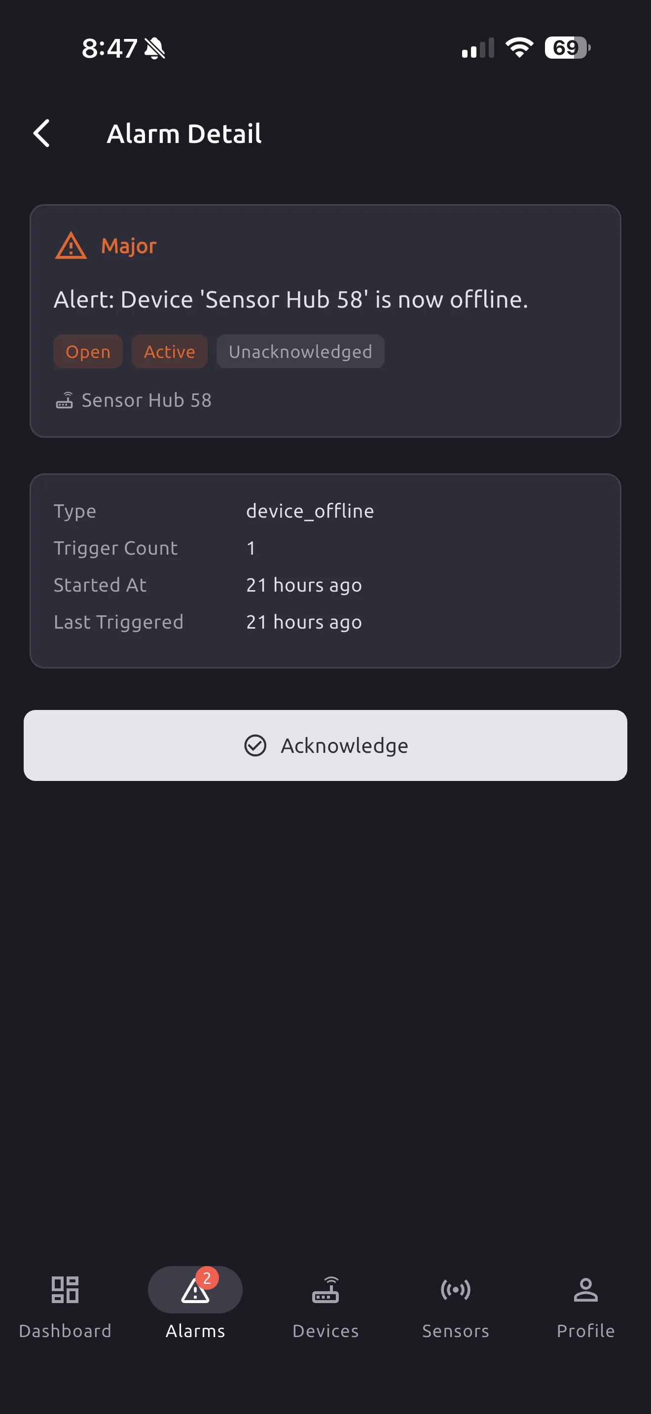 An alarm's detail screen showing its severity, its Open/Closed and Active/Cleared badges, and the Acknowledge button.